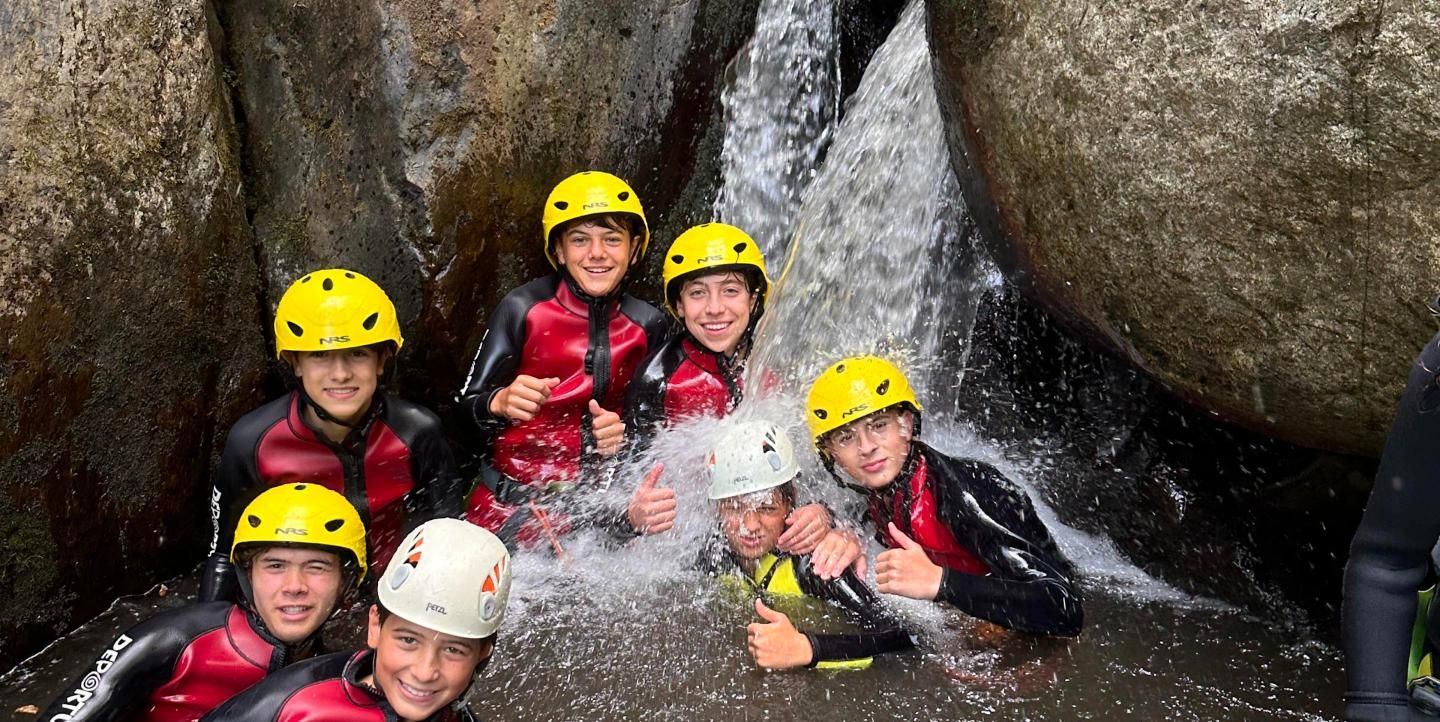 Grupo bajo una cascada en un barranco