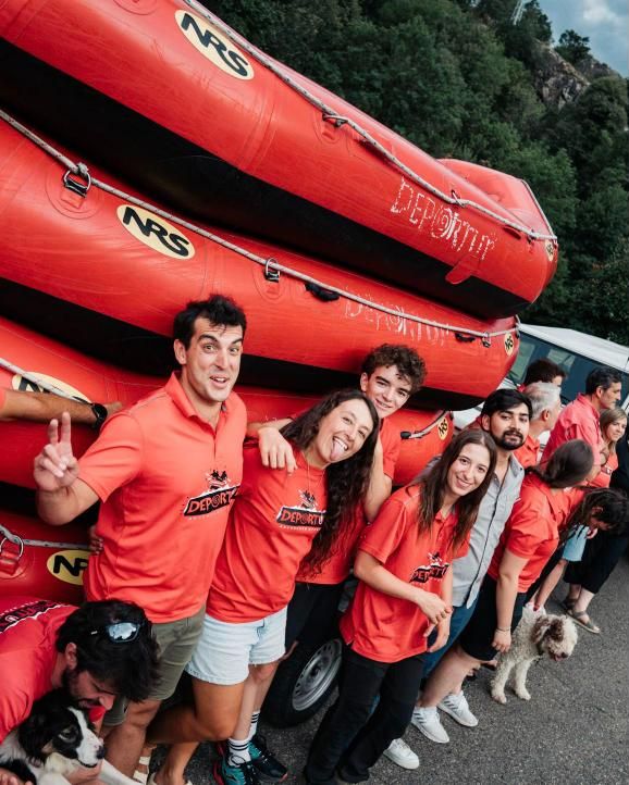 Parte del equipo haciendo el tonto junto a las barcas apiladas